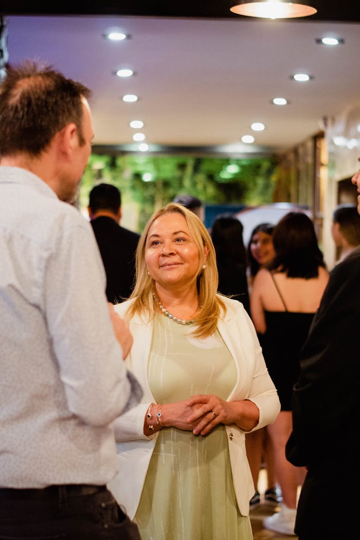 gallery-5 A group of adults mingling at a lively indoor celebration.
